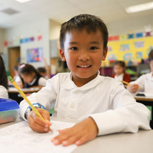 Student Writing and Smiling