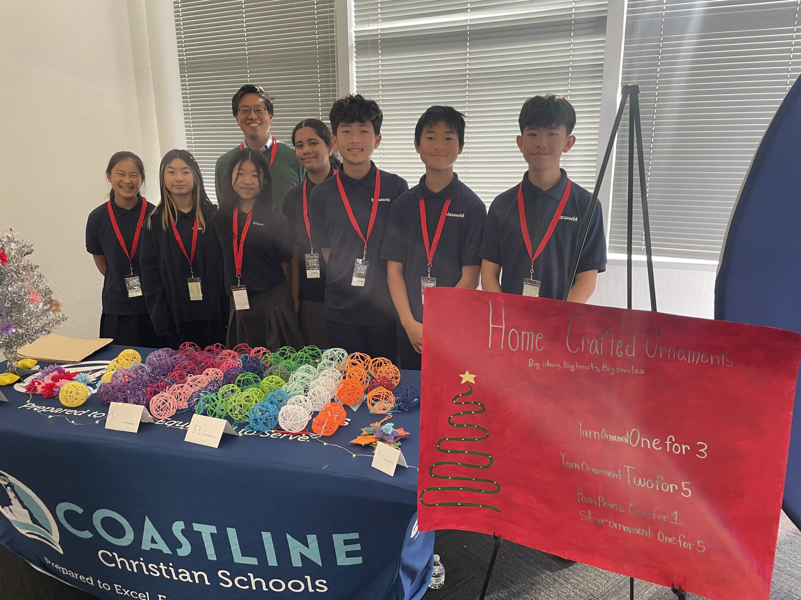 Group of students smiling at their booth